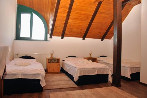 a bedroom with two beds and a window at Kantár Fogadó és Étterem in Vitnyéd