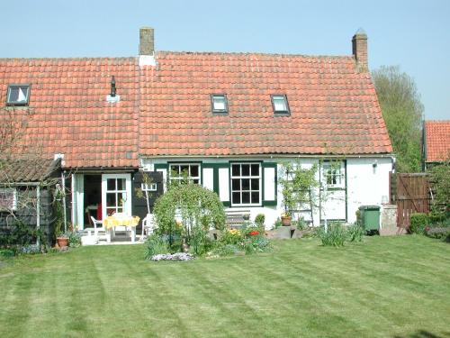 een wit huis met een rood dak en een tuin bij Ferienhaus Gapinge Walcheren Zeeland in Veere