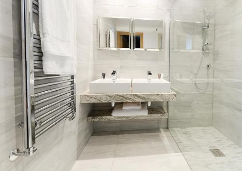a white bathroom with a sink and a shower at Fence Gate Lodge in Burnley