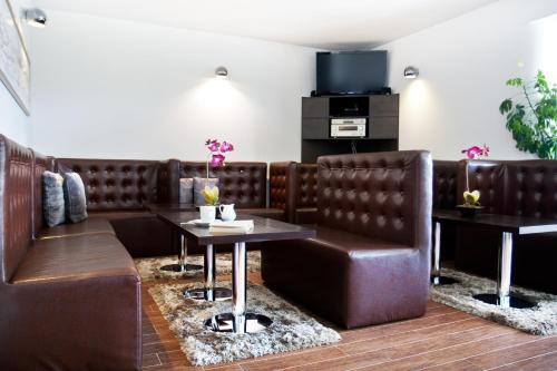 una sala d'attesa con tavolo e cabine in pelle marrone di Villa Park a Bukowina Tatrzańska