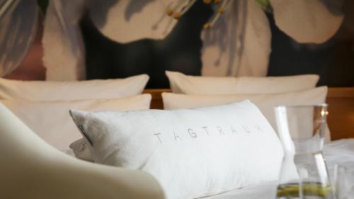 a pillow with the word vacation written on it on a bed at WeinHotel Fritz Walter in Niederhorbach