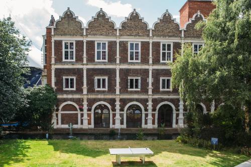 a bench in front of a large brick building at Safestay London Kensington Holland Park in London