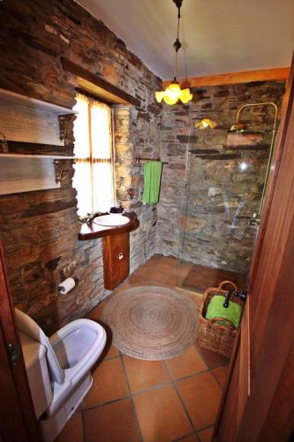 a stone bathroom with a toilet and a shower at Casa Campelo in Cedeira