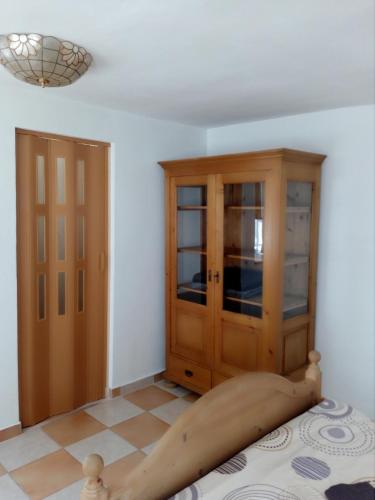 a bedroom with a bed with a wooden cabinet at Penzion U kozy in Chřibská