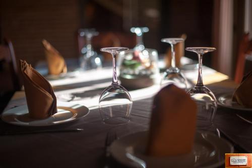 einen Tisch mit Weingläsern und Tafeln darauf in der Unterkunft La Posada de Alcudia in Brazatortas