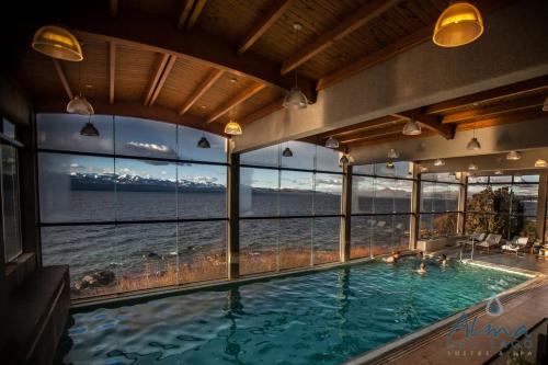 a large indoor swimming pool with a view of the ocean at Alma Del Lago Suites & Spa in San Carlos de Bariloche