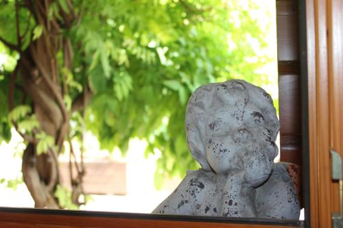 a statue of a person sitting in a window at B&B - Relais de charme la Caminella in San Pietro in Cariano