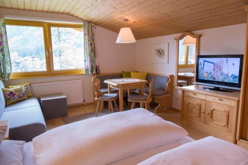 a bedroom with a bed and a table with a television at Haus Braunarl in Lech am Arlberg