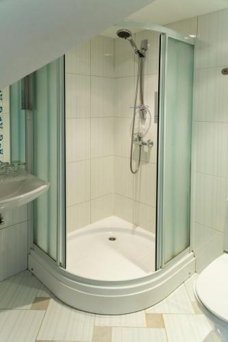 a shower with a glass door in a bathroom at Arno Apartments in Kuressaare