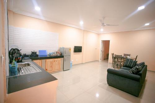 a kitchen and a living room with a couch at Regal Apartments in Kololi