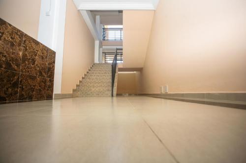 an empty hallway with stairs in a building at Regal Apartments in Kololi