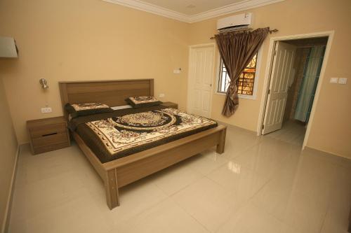 a bedroom with a bed and a window at Regal Apartments in Kololi