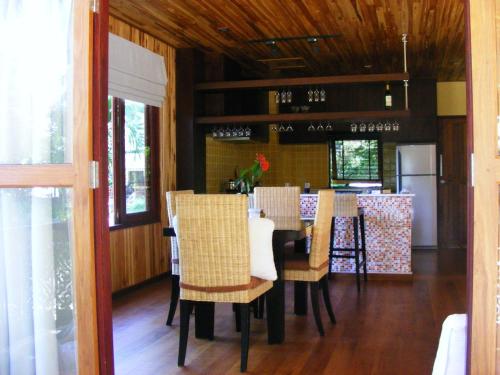 a dining room with a table and chairs and a refrigerator at Baan Banyan Villa, wood house short walk to Mae Nam beach in Mae Nam