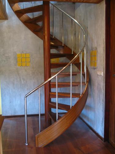 a wooden spiral staircase in a room at Baan Banyan Villa, wood house short walk to Mae Nam beach in Mae Nam