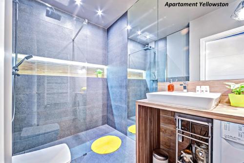 uma casa de banho com um chuveiro e um lavatório. em Apartamenty Homely Place 1 - Parking em Poznań