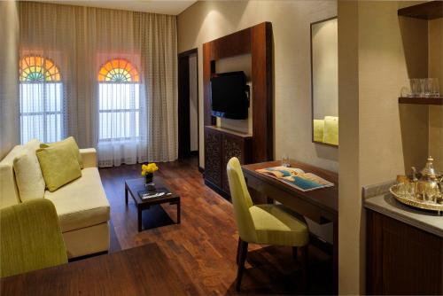 a room with a living room with a table and a couch at Souq Waqif Boutique Hotels - Tivoli in Doha