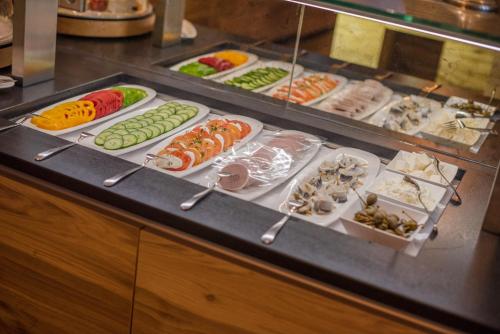 a buffet line with many different types of food at Hotel Almschlössl & Schrotteralm in Obertauern