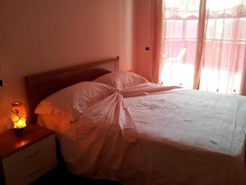 a bedroom with a white bed with a window at Case Vacanze Rocca in Bastia Umbra