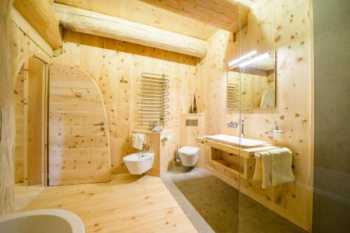 a bathroom with a toilet and a sink at Hotel Pradell in Ortisei
