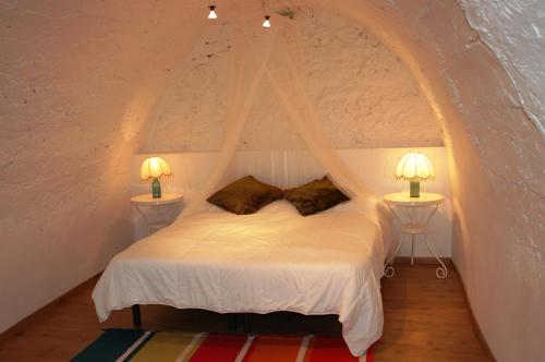 a bedroom with a white bed with two lamps at Cal Alejandro in Montsonis