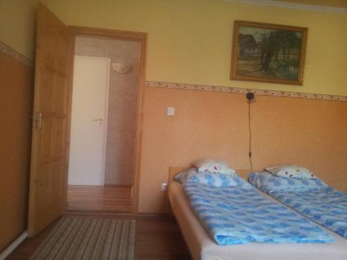 two beds in a small room with a door at Marcsi Apartman in Gyula