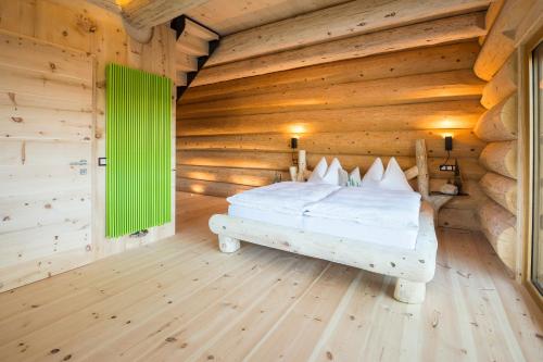 a bedroom with a bed and a wooden floor at Hotel Pradell in Ortisei