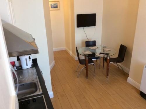 ウェックスフォードにあるWexford Town Opera Mews - 2 Bed Apartmentのテーブルと椅子、キッチンが備わる小さな客室です。