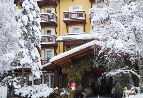 a large building with snow covered trees in front of it at Lodge Park in Megève