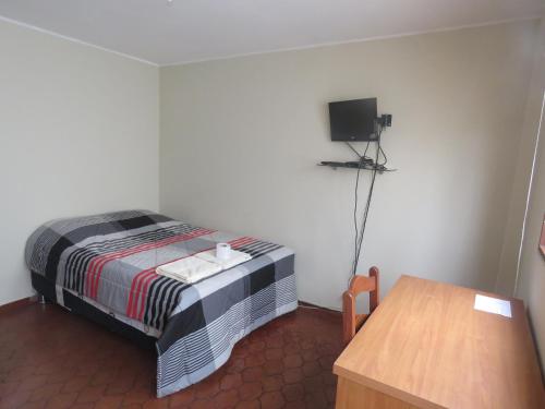 a small room with a bed and a television at Casa particular de Jorge Edinson in Lima