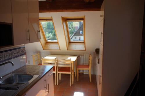 バイアースブロンにあるFerienwohnung del Arteのキッチン(テーブル、椅子付)、窓2つが備わります。