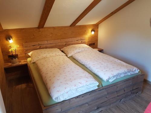 Bett in einem Zimmer mit zwei Kissen darauf in der Unterkunft Hoamalm in Großarl