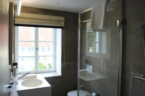 a bathroom with a sink and a glass shower at BA Hotel by WMM Hotels in Babenhausen
