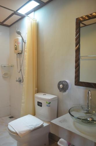 a bathroom with a toilet and a sink and a mirror at Baan Aew Pai in Pai
