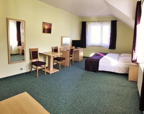 pokój hotelowy z łóżkiem, biurkiem i stołem w obiekcie Pokoje Gościnne w Dolinie Szczęścia w Szklarskiej Porębie