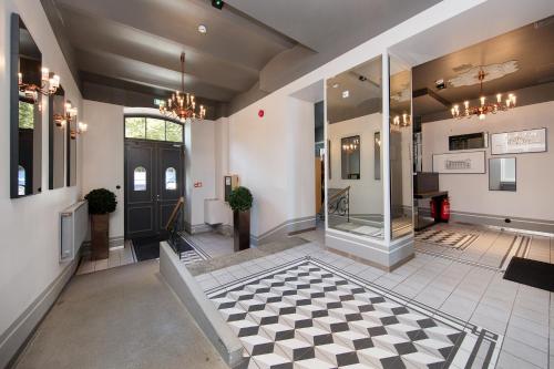 a lobby with a black door and a checkered floor at Mere Puiestee Apartment in Tallinn