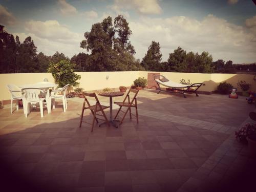 a patio with chairs and a table and a fence at Al Ciclamino in Monastir