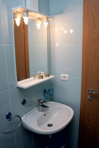 a bathroom with a sink and a mirror at Pension Andronic in Timişoara