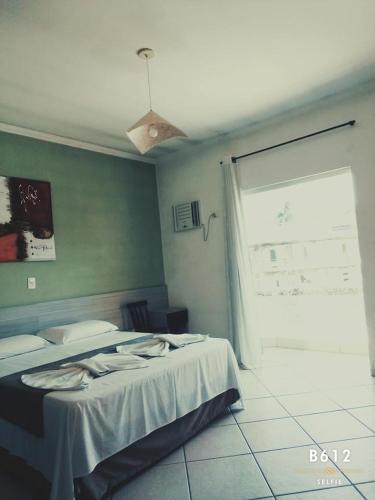 a bedroom with two beds and a window at Pousada Hippocampus in Juquei