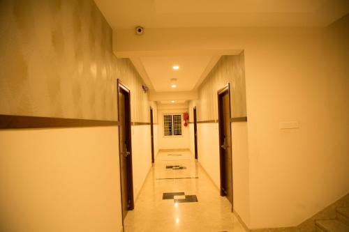 a hallway with two doors and a long corridor at Hotel Grand Tree in Coimbatore