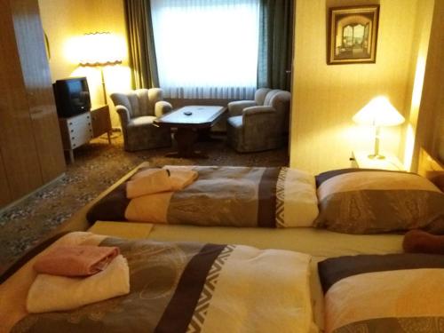 a hotel room with three beds in a room at Pension Cecilie in Braunlage