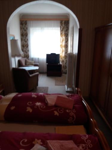 a bedroom with a bed and a living room with a window at Pension Cecilie in Braunlage
