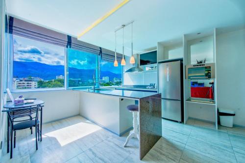 a kitchen with a table and a large window at Viengping Mansion Chiang Mai - Heart of Nimman, Shopping & Cafes in Chiang Mai