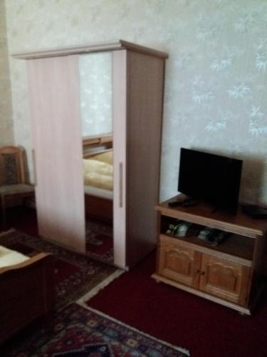 een kamer met een deur naar een slaapkamer met een televisie bij Pension Cecilie in Braunlage