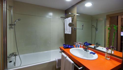een badkamer met een wastafel, een douche en een bad bij Evenia Zoraida Resort in Roquetas de Mar