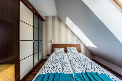 1 dormitorio con cama con sábanas azules y escalera en Designer Home Synagogue, en Budapest