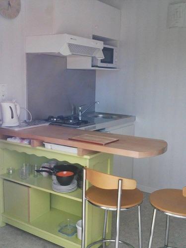 - une petite cuisine avec un évier et 2 chaises dans l'établissement La Halte, à Villeret