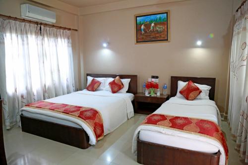 a bedroom with two beds and a window at Hotel Parkland in Sauraha