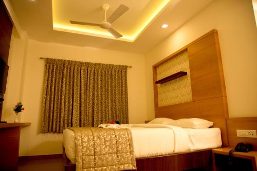 a bedroom with a bed and a ceiling fan at Hotel Grand Tree in Coimbatore