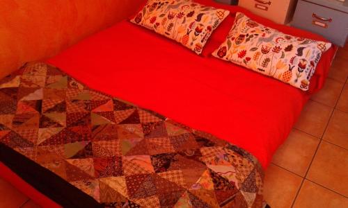 a bed with a red blanket and pillows on it at B&B Villa Milena in Ariano Irpino