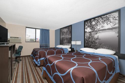 a hotel room with two beds and a flat screen tv at Super 8 by Wyndham Willmar in Willmar